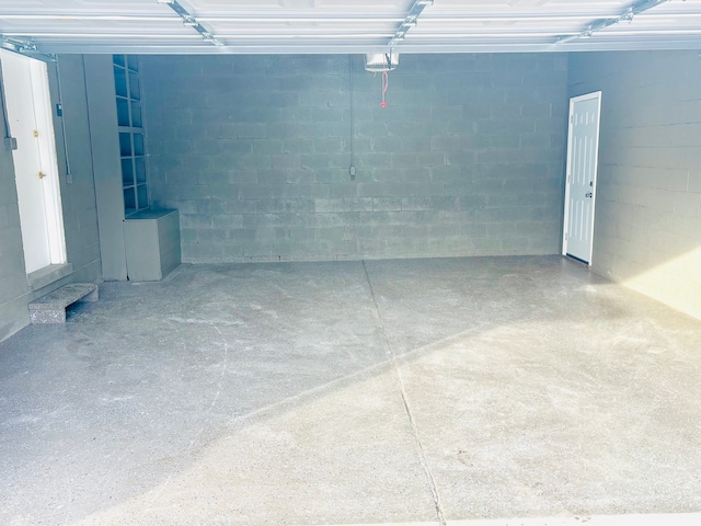 garage with concrete block wall and a garage door opener