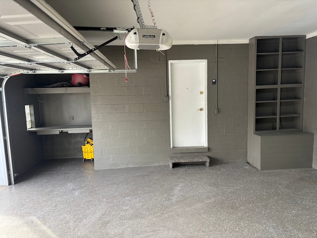 garage featuring concrete block wall and a garage door opener