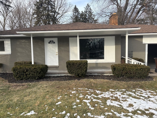 snow covered property entrance featuring a lawn