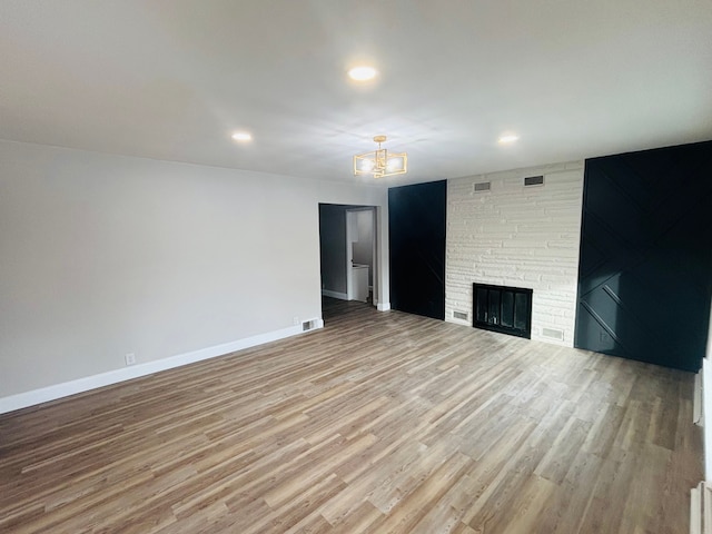 unfurnished living room with a fireplace and light wood-type flooring