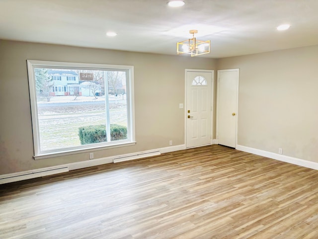 foyer with baseboard heating, light hardwood / wood-style floors, and a wealth of natural light