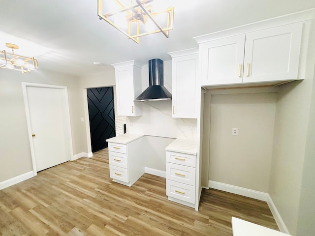 unfurnished office featuring light wood-type flooring, baseboards, and an inviting chandelier