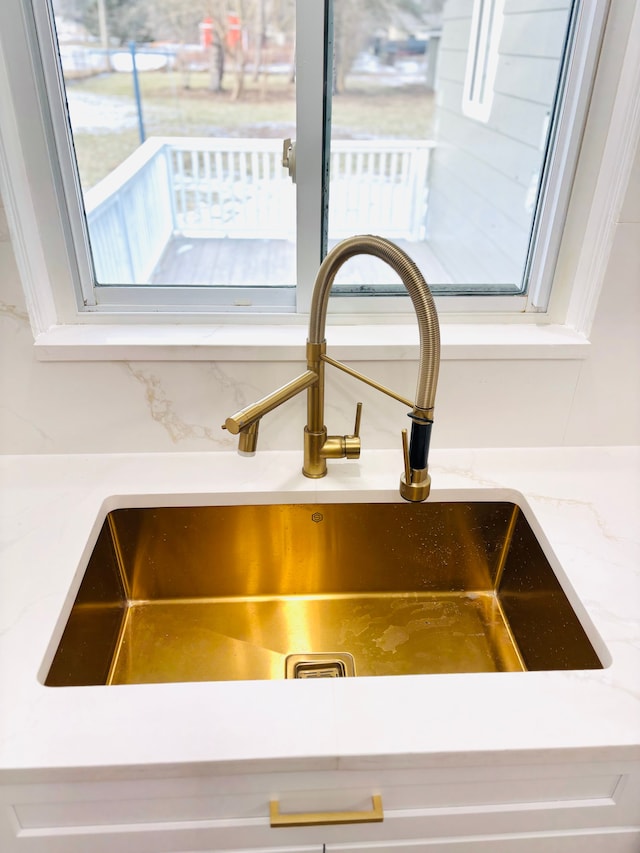 interior details featuring light stone countertops and a sink