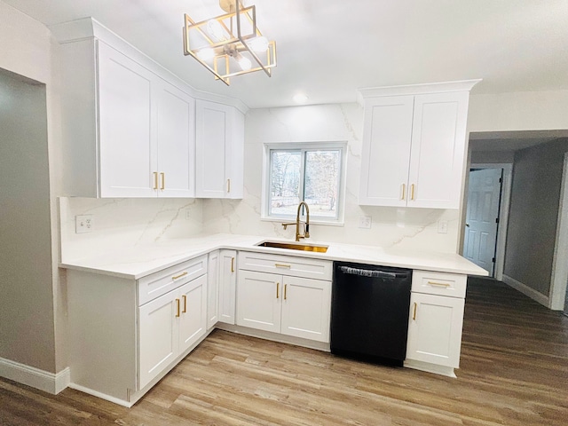 kitchen with sink, black dishwasher, light hardwood / wood-style floors, white cabinets, and decorative light fixtures