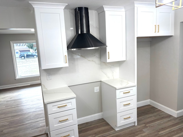 kitchen with dark wood-type flooring, wall chimney range hood, white cabinets, and decorative backsplash