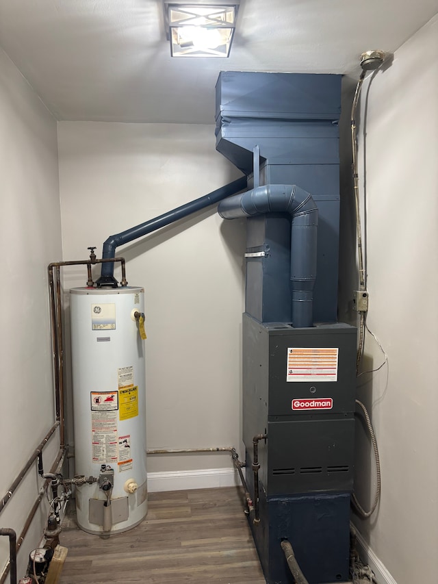 utility room featuring a garage and water heater