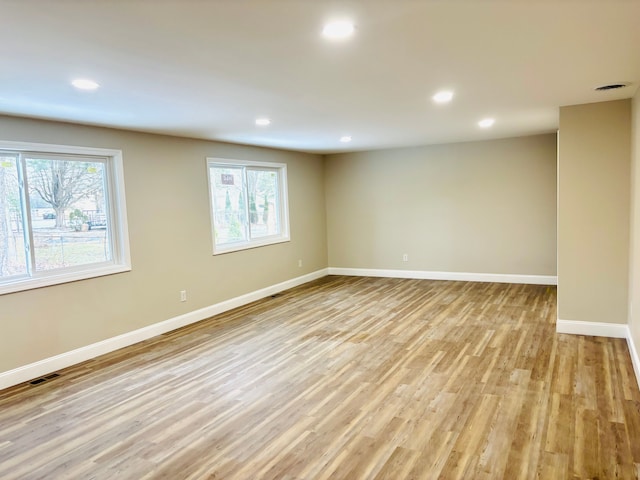 spare room with recessed lighting, light wood-style floors, and baseboards