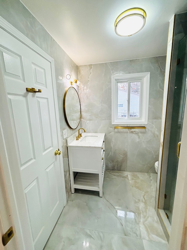 bathroom with vanity, tile walls, and toilet