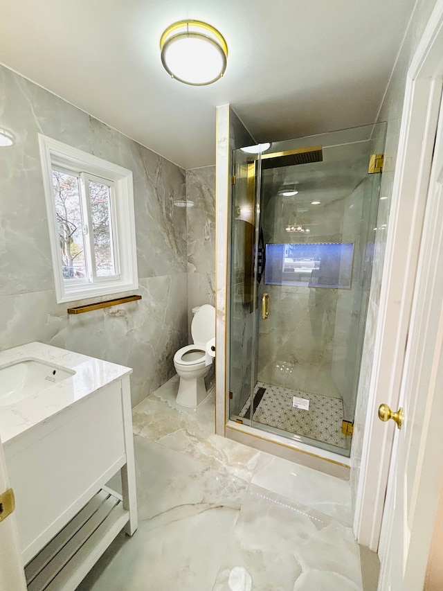 full bath with vanity, a shower stall, tile walls, toilet, and marble finish floor