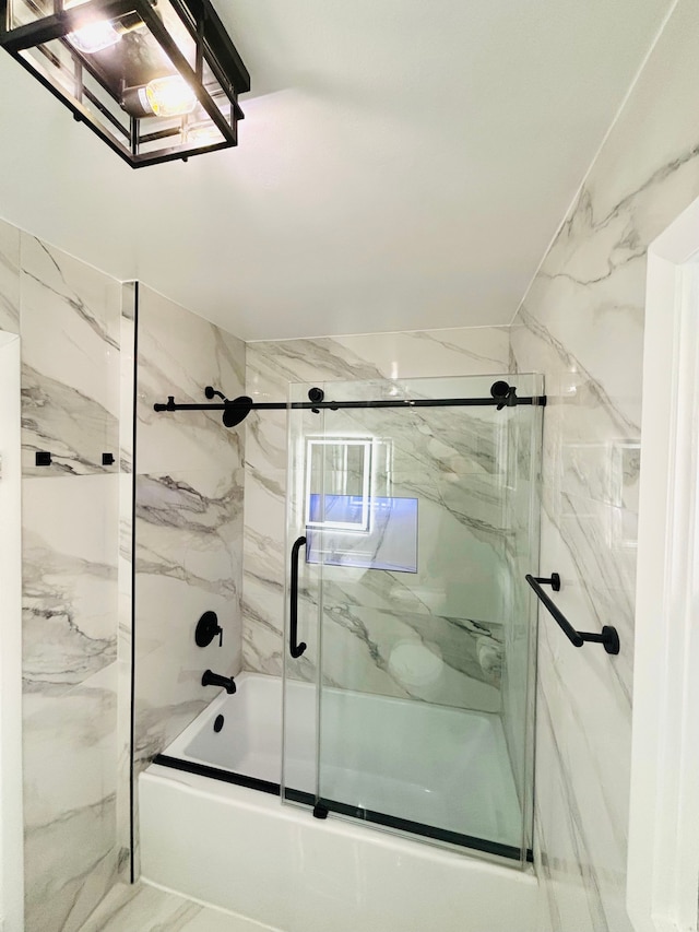 bathroom featuring combined bath / shower with glass door