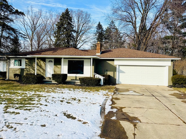 single story home with driveway, a chimney, and an attached garage