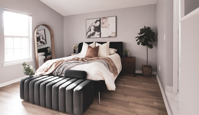 bedroom featuring lofted ceiling and hardwood / wood-style floors