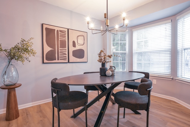 dining space featuring wood-type flooring and a notable chandelier