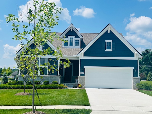 craftsman inspired home featuring a garage and a front lawn