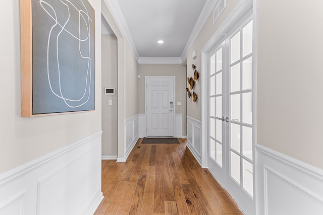 doorway to outside featuring ornamental molding and wood-type flooring