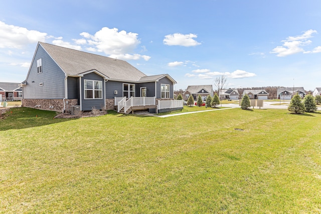 back of property with central AC and a yard