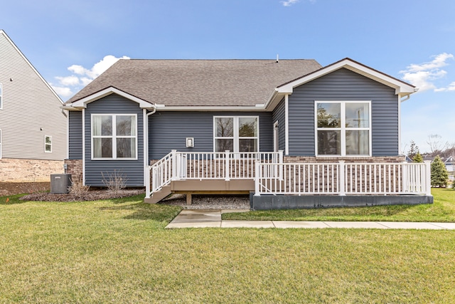 rear view of house with central AC unit, a deck, and a lawn