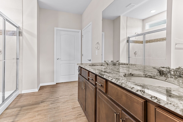 bathroom featuring wood-type flooring, vanity, and walk in shower