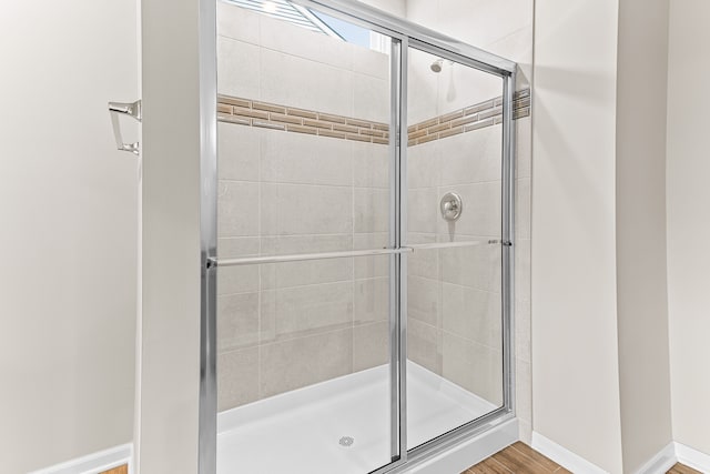 bathroom featuring hardwood / wood-style flooring and walk in shower