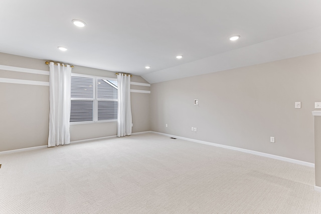 unfurnished room with vaulted ceiling and light colored carpet