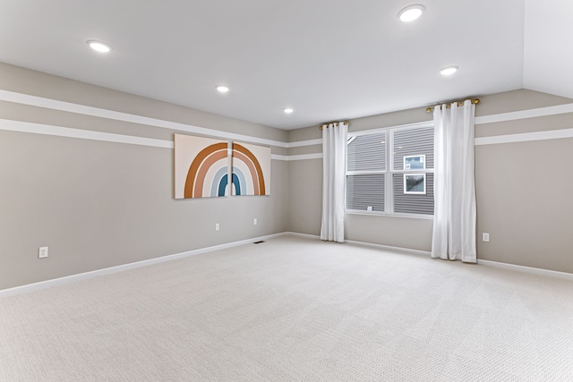 unfurnished room with vaulted ceiling and light carpet