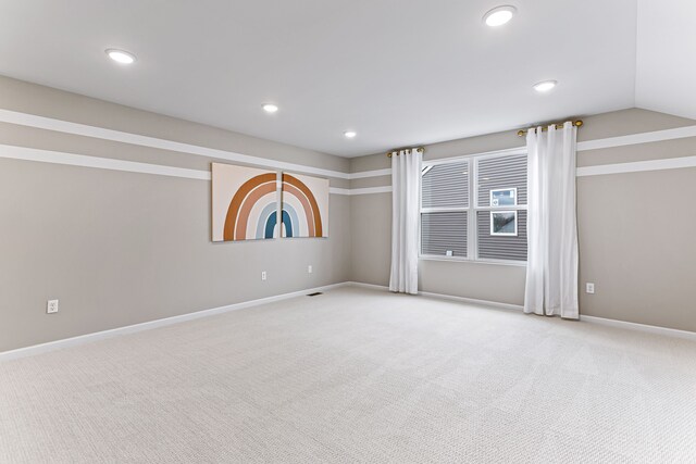 carpeted empty room featuring lofted ceiling