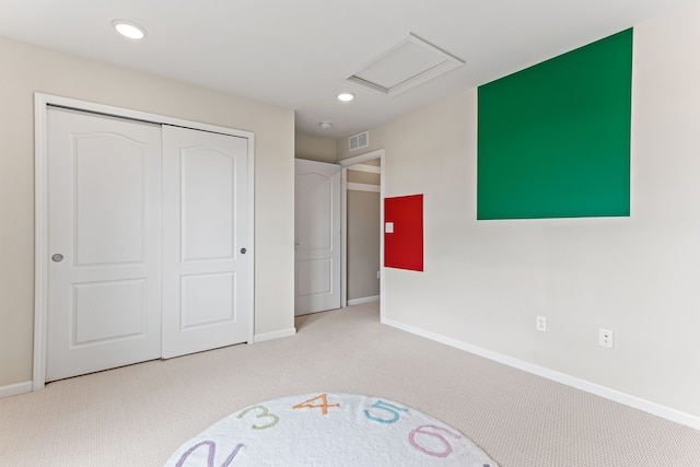 unfurnished bedroom with light colored carpet and a closet