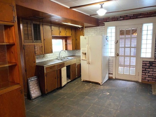 kitchen with tasteful backsplash, white refrigerator with ice dispenser, and sink