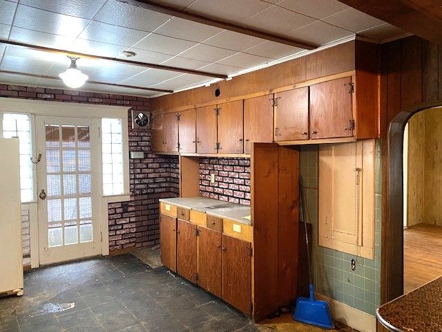 kitchen featuring brick wall and white fridge