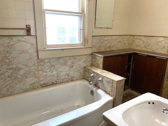 bathroom featuring sink and a bath