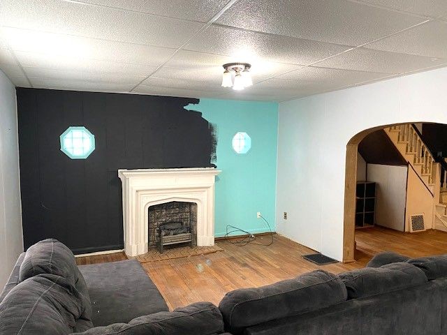 living room with wood-type flooring and a paneled ceiling