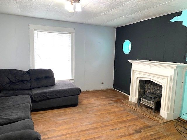 living room with hardwood / wood-style floors and a drop ceiling