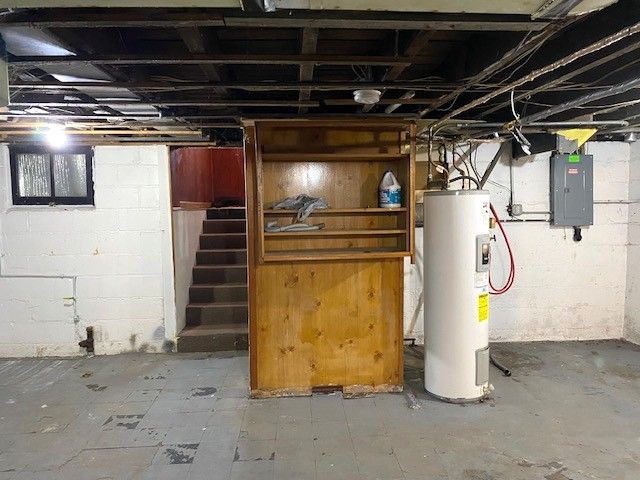 basement featuring electric panel and electric water heater