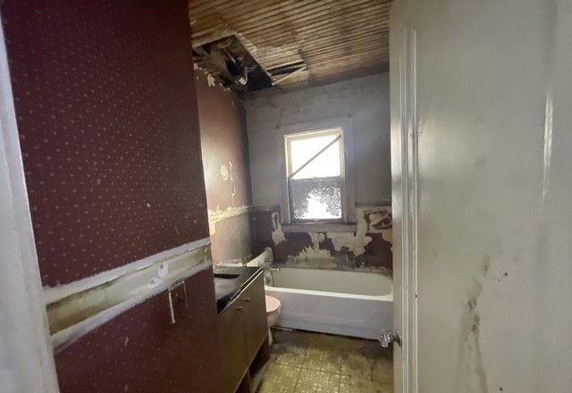 bathroom with vanity, toilet, and a tub