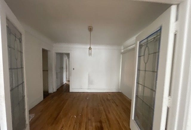 unfurnished dining area featuring dark wood-type flooring