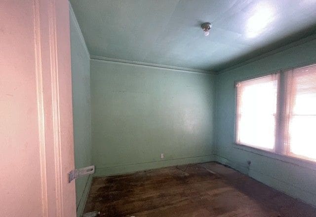 empty room featuring hardwood / wood-style flooring and ornamental molding