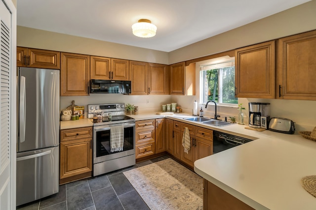 kitchen featuring sink, black appliances, and dark tile patterned floors