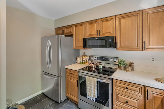 kitchen with appliances with stainless steel finishes and dark tile patterned floors