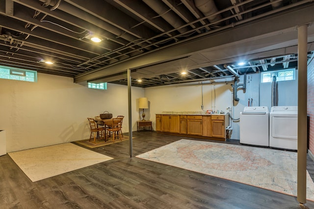 basement with dark wood-type flooring and independent washer and dryer