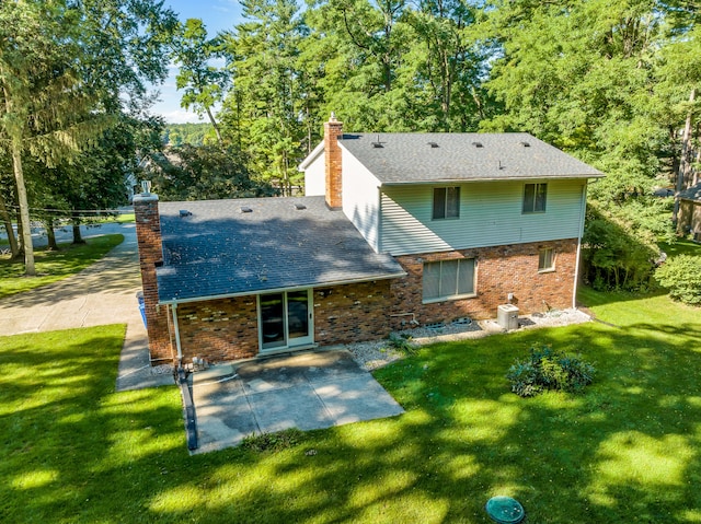 rear view of house featuring a patio area and a lawn