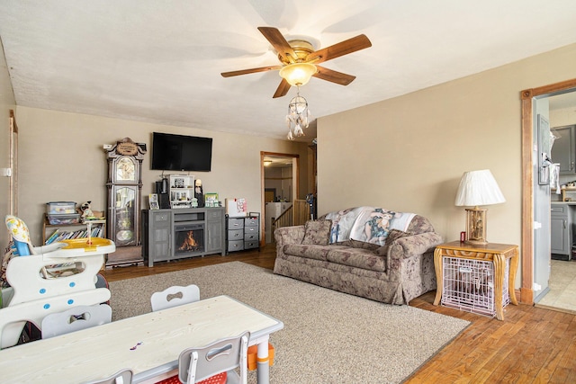 living room with ceiling fan and light wood-type flooring