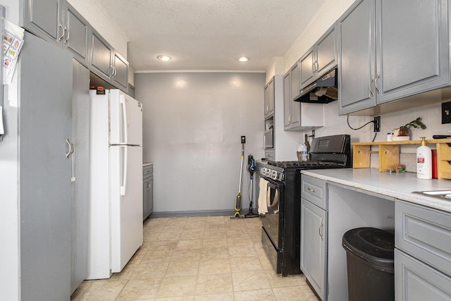 kitchen with black gas range oven, gray cabinets, a textured ceiling, and white refrigerator