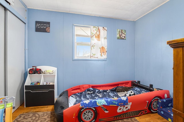 bedroom with hardwood / wood-style floors and a closet