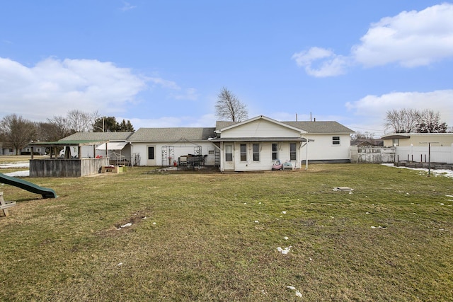 rear view of property featuring a yard and a playground