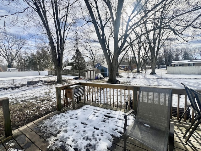 snow covered deck with a shed