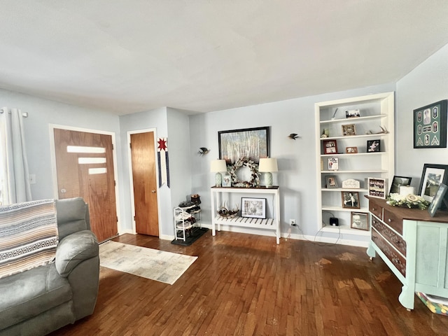 living room with dark hardwood / wood-style flooring and built in shelves