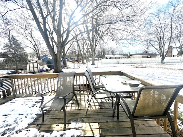 snow covered deck with a storage shed