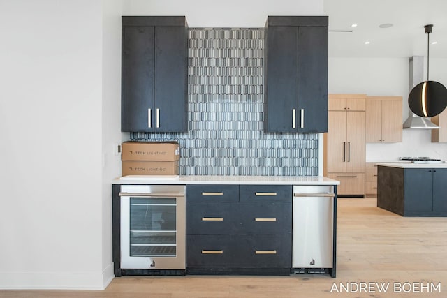 kitchen featuring pendant lighting, blue cabinets, beverage cooler, and backsplash