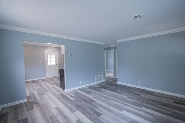 unfurnished room with wood-type flooring and ornamental molding