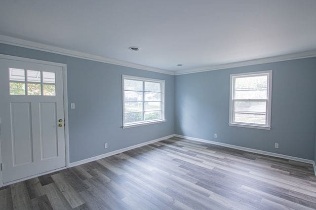 entrance foyer with ornamental molding and dark hardwood / wood-style flooring